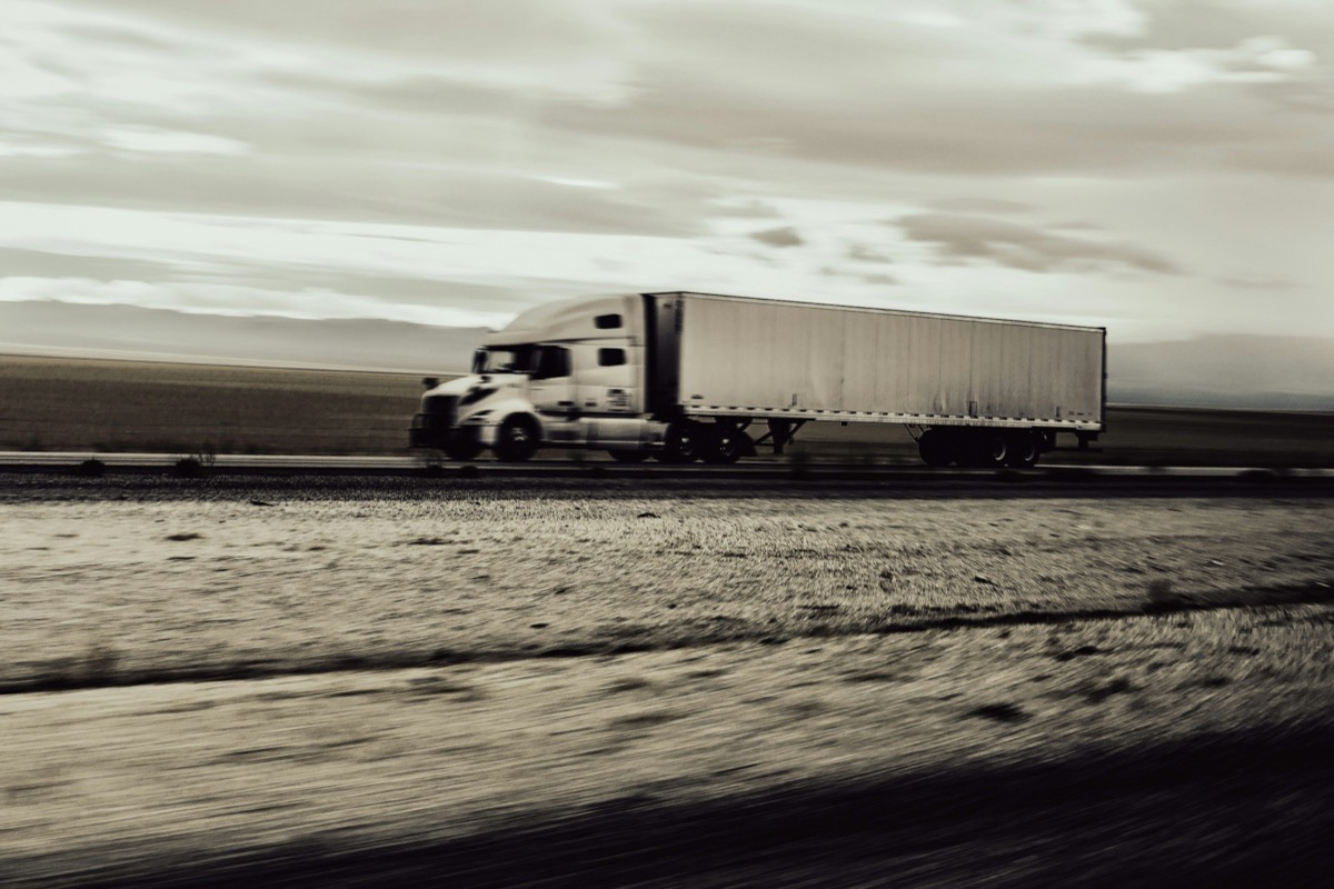 A working tractor-trailer moving along an open highway
